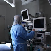 Une infirmière vérifie de l'équipement dans une salle d'opération.