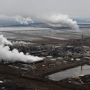 Vue aérienne des installations d'extraction des sables bitumineux de Syncrude avec celles de Suncor en arrière-plan, près de Fort McMurray, en Alberta.