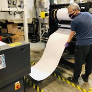 Un homme surveille la fabrication d'un rouleau de filtre carbone.