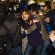 La jeune femme fait partie d'un groupe de manifestants bousculés par des policiers.