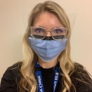 Une infirmière portant un masque et une visière.