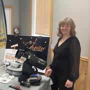 Un télescope est posé sur une table entourée de deux personnes. 