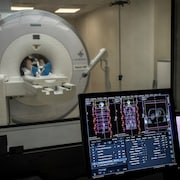 Un patient entre dans un tomographe. 
