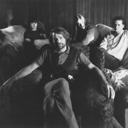 Les membres du groupe The Tragically Hip posent dans des canapés. 