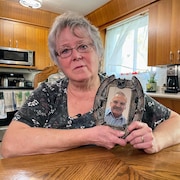 Thelma Hogue tient une photo de son mari, Doug, contre son coeur.