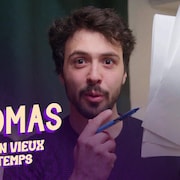 Le youtubeur Thomas Gauthier avec un crayon et des feuilles dans les mains.