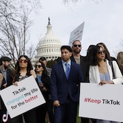 Des personnes tiennent des pancartes en soutien à TikTok devant le Capitole.