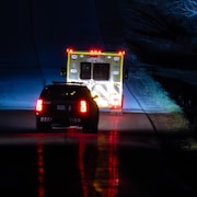Un véhicule de police escorte une ambulance.