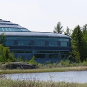 Un bâtiment en forme de dôme à côté d'un lac. 