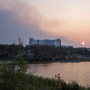 De la fumée surplombe l'hôpital territorial Stanton de Yellowknife, le 15 août 2023.