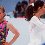 Tonya Harding, le visage triste, et Nancy Kerrigan, lui faisant dos, souriante sur la patinoire des Jeux olympiques de Lillehammer.