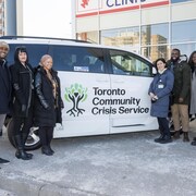 Un groupe pose devant une camionnette du programme Toronto Community Crisis Service
