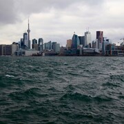 Vue du centre-ville de Toronto, la Tour du CN et les gratte-ciels à partir du Lac Ontario, une journée grise et nuageuse. 