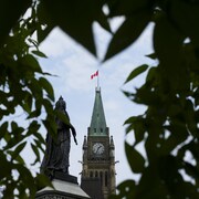 La tour de la Paix sur la colline du Parlement photographiée à travers des feuilles à Ottawa le mardi 27 août 2024.