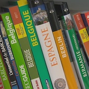 Guides de voyage dans une bibliothèque.