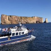 Un bateau de croisière plein de touristes et, en arrière-plan, le rocher Percé.