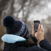 Une touriste photographie la statue de Bonhomme Carnaval devant l’Assemblée nationale.