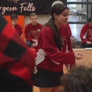 Une élève vêtue d'un chandail rouge qui participe à un match d'improvsation
