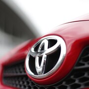 Le sigle de Toyota sur le devant d'une voiture.