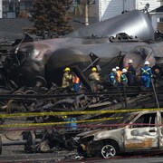 Des pompiers constatent l'ampleur des dégâts du déraillement du train.