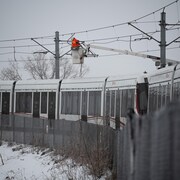 Un travailleur tente de réparer les câbles du train léger d'Ottawa, le vendredi 6 janvier.