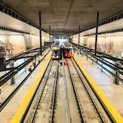Deux trains roulent à la station du train léger.