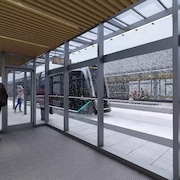 Une représentation virtuelle montre des gens qui attendent le tramway à une station en hiver. 
