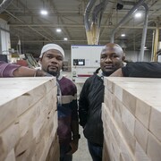 Deux hommes posent dans une usine.