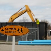 Un panneau indiquant corridor scolaire près d'un chantier. 