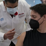 Un pharmacien administre un vaccin à Justin Trudeau.