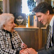 Justin Trudeau serre la main de Miriam Ziegler, survivante du camp d'Auschwitz-Birkenau.