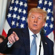 Donald Trump parle sur une estrade.