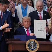 Un homme tient un papier.