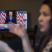 Une femme travaille à son poste alors qu'elle regarde Fox News diffuser le discours d'adieu du président Donald Trump. 