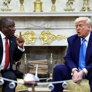 Cyril Ramaphosa lève le doigt en regardant Donald Trump alors que les deux hommes semblent débattre.