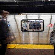 Des personnes débout devant un métro à Toronto