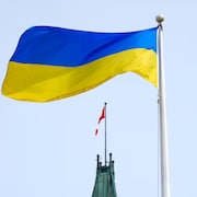 Des drapeau ukrainien et canadien flottent dans les airs.