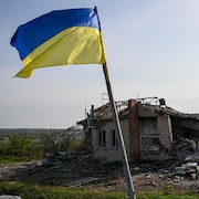 Un drapeau ukrainien est affiché devant une maison détruite près d'Izioum, dans l'est de l'Ukraine, le 1er octobre 2022.
