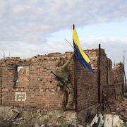 Un commandant lève le drapeau ukrainien.