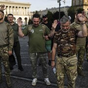 Un groupe de militaires ukrainiens prient lors d'un service religieux à Kiev..