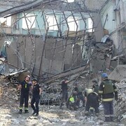 Les services d'urgence sur le site d'un immeuble d'habitation lourdement endommagé par un missile russe à Kryvyï Rih.