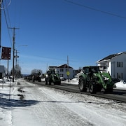 Des tracteurs circulent sur une rue.