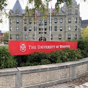 Une affiche devant un édifice sur laquelle on peut lire, en anglais, « l'Université de Winnipeg ».