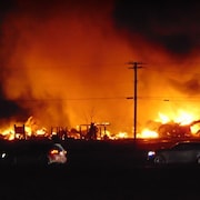 Photo prise le soir d'un incendie qui rougeoie près d'une autoroute.