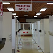 Un corridor avec des cubicules de vaccination. 