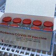 Une boîte de 10 fioles contenant chacune 10 doses de vaccin, dans un réfrigérateur.