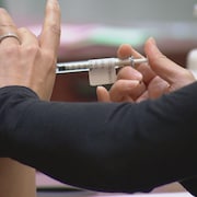 Une seringue est utilisée pour administrer le vaccin. 
