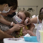 Une enfant de 3 ans reçoit son vaccin contre la COVID-19 au centre commercial Victoria Square Mall à Regina, en Saskatchewan, le 22 juillet 2022.