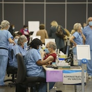 Des travailleurs de la santé vaccinent au Palais des Congrès de Montréal. 