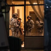 Des membres de l'escouade tactique dans l'entrée du complexe Bellaria Residences le soir de la fusillade.
